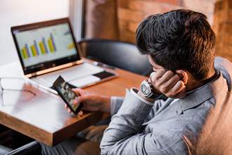 man looking at phone instead of computer