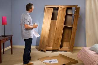 man looking at poorly constructed cabinet