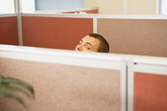 man looking over cubicle wall