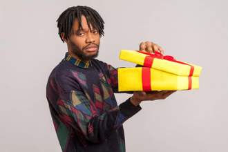 man looking very dissatisfied as he opens a gift box