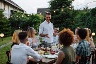 man making a speech at a dinner party with friends