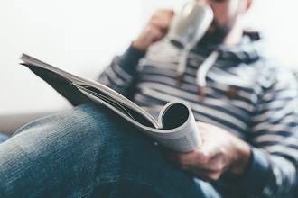 man reading magazine with coffee