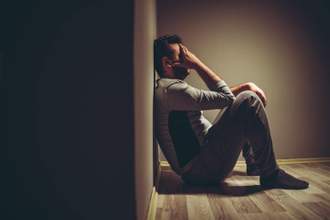 man sitting on the floor looking sullen