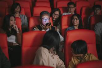 man talking on the phone loudly during a movie