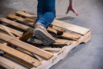 man tripping on wooden pallet