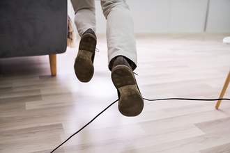 man tripping over electrical cord
