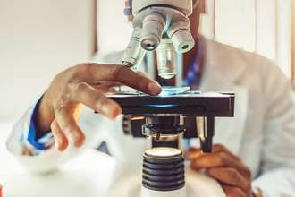 man using microscope