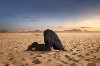 man with head buried in sand