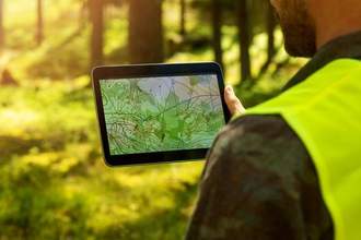 man working with topographic map data on digital tablet