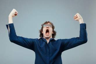 man yelling into the sky with his hands raised in the air