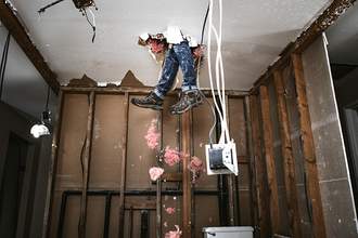 mans legs falling through ceiling