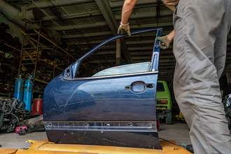 mechanic working on car door