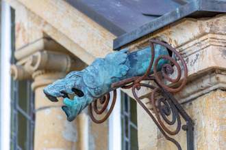 medium sized copper rain gutter with dragon mouth protruding off of the corner roof