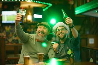 men raising glasses of beer and having fun during celebration