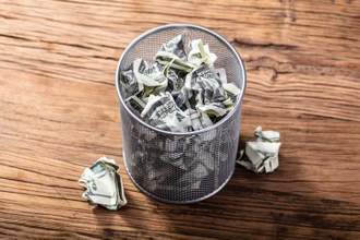 money crumpled and thrown into the trash