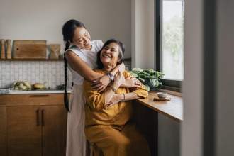 mother and daughter hugging and smiling at one another