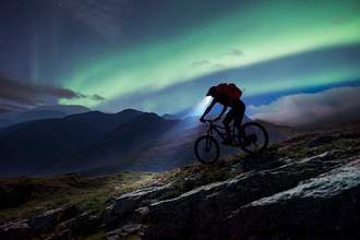 mountain biker riding on mountain at night