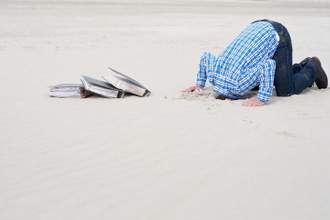office worker hiding head in sand