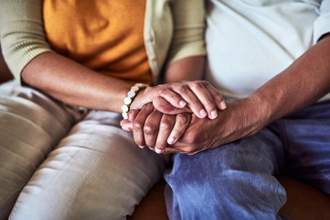 older couple sitting next to each other holding hands