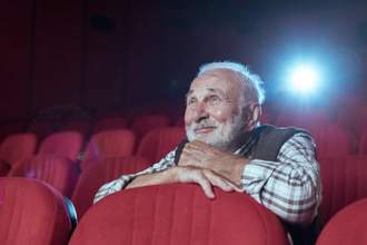 older man absorbed in the movie hes watching