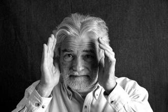 older man holding his hands at the sides of his head