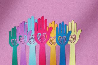 paper cut out of hands with hearts in the middle
