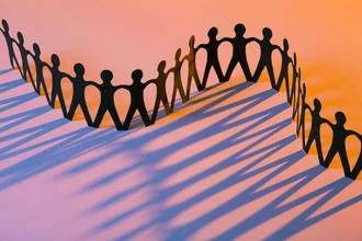paper human chain on an orange and purple background