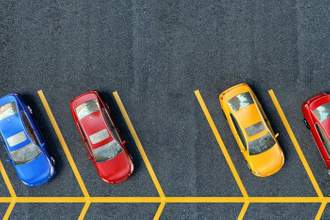 parked cars lined in a row with one free space in the middle