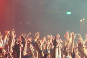 people with hands raised at concert
