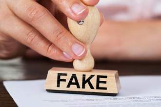 person hand stamping fake onto a document
