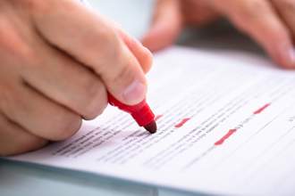 person highlighting a page with a red marker