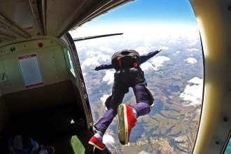 person leaping out of an airplane skydiving