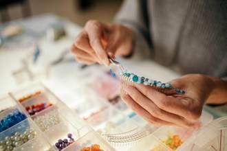 person putting together a beaded crown