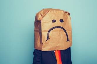 person with frowny paper bag over head
