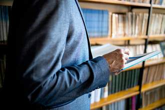 professor holding book in library
