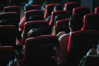 rear view of people in a movie theater watching the screen