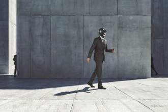 robot dressed as a business man walking on the sidewalk