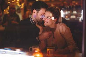 romantic couple sitting close together at a restaurant