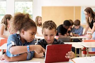 school kids in class using a digital tablet at school
