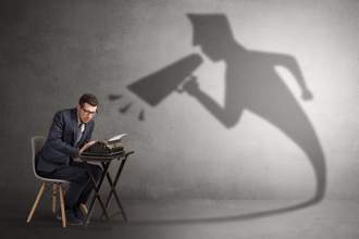 shadow of a person with a megaphone yelling at a man with a typewriter