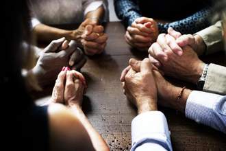 sitting in a circle with their hands clasped