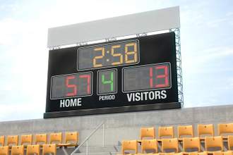 sports scoreboard sitting above stadium seats