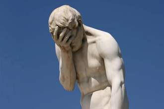 statue of a man looking forlorn with his face in his hands