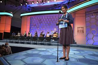 student standing at the microphone spelling out a word