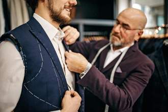 tailor working on the construction of a mans suit jacket