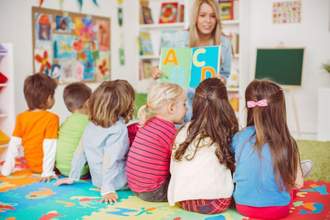 teacher reading the abcs to children in her class