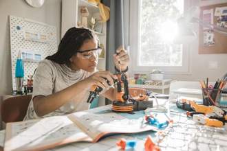 teenager working in their room on a robotics project