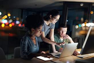 three coworkers looking at computer