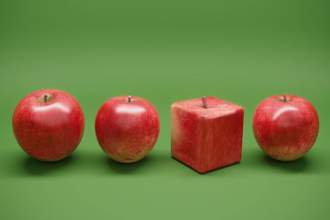 three round apples next to an unnatural square shaped apple