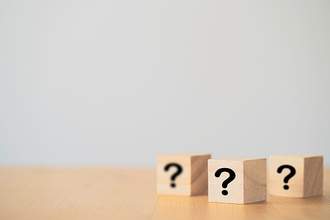 three wooden blocks with question marks on them